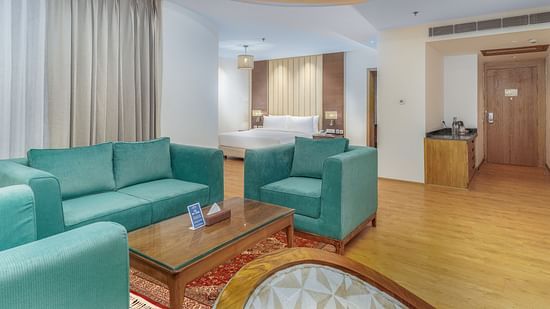 A Spacious living room featuring plush teal coloured sofas - Sarovar Premiere, Srinagar